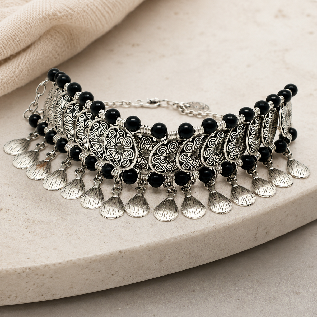 Angled view of a black bead collar necklace with fan-shaped charms.