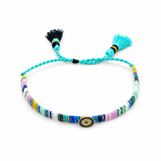 Colorful evil eye bracelet with woven threads and tassel ties on a white background.