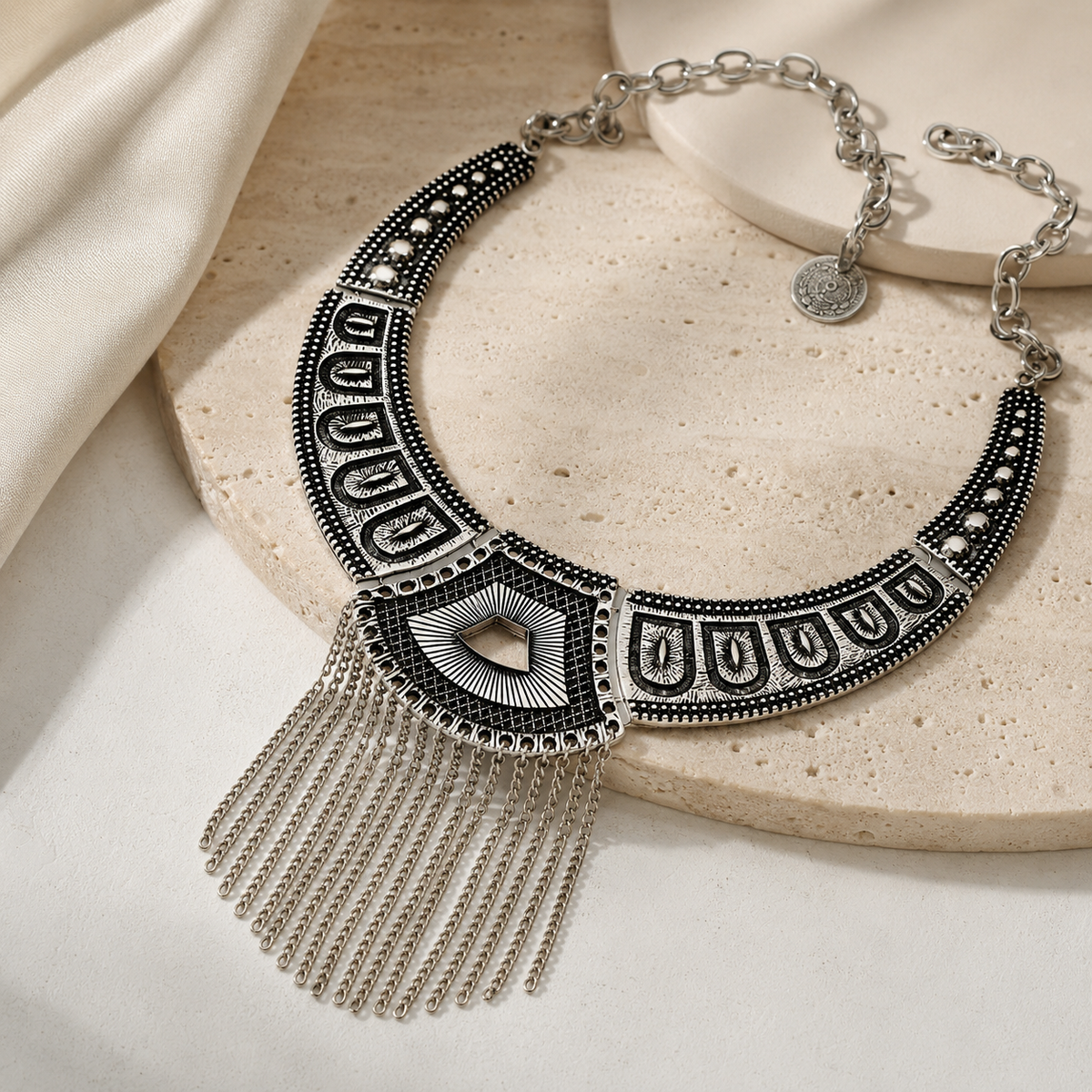 Angled view of a black geometric chain fringe statement necklace.