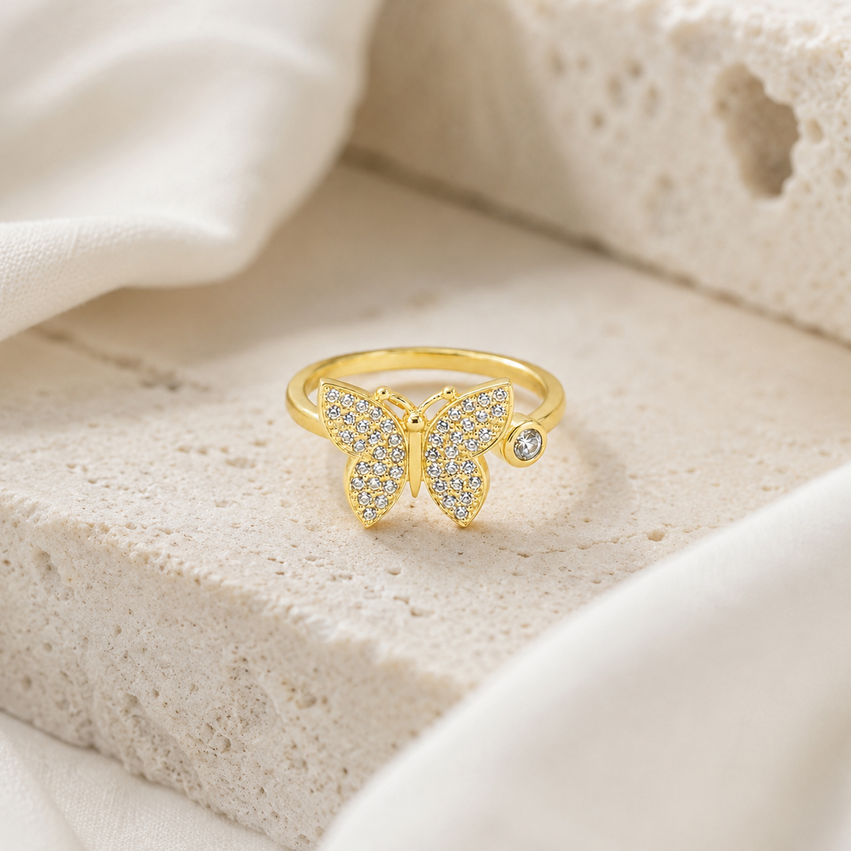Butterfly statement ring in a gold-plated finish with sparkling stone-like accents.