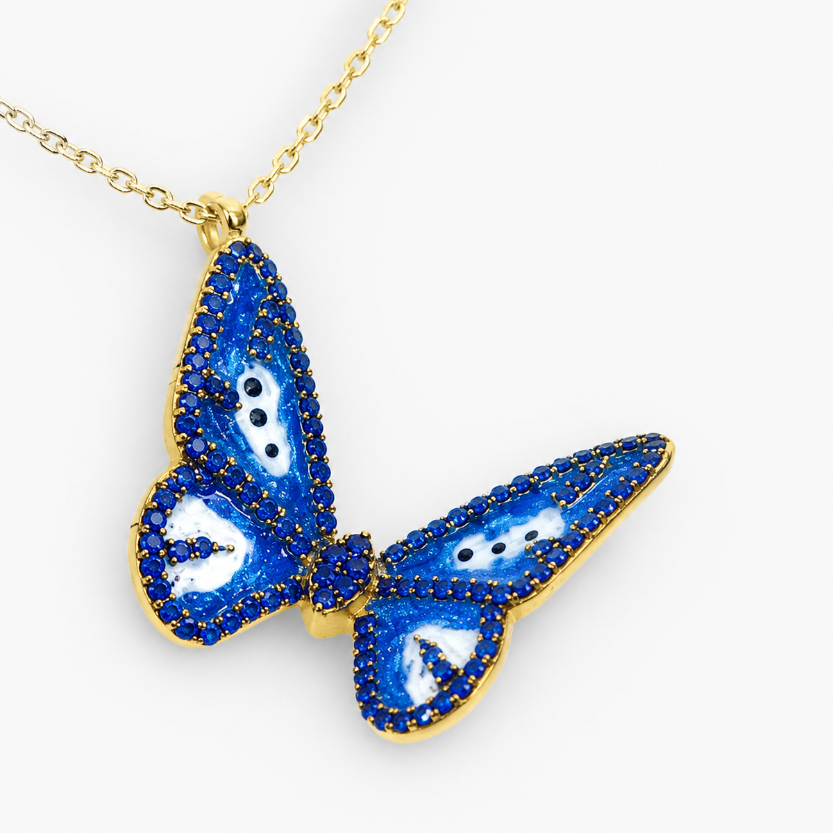 Close view of the blue butterfly pendant with gold-tone edging.