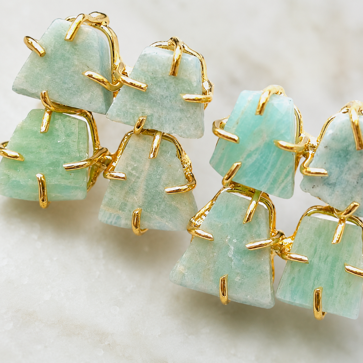 Close view of rough apatite stones with gold-plated prongs and an organic shape.