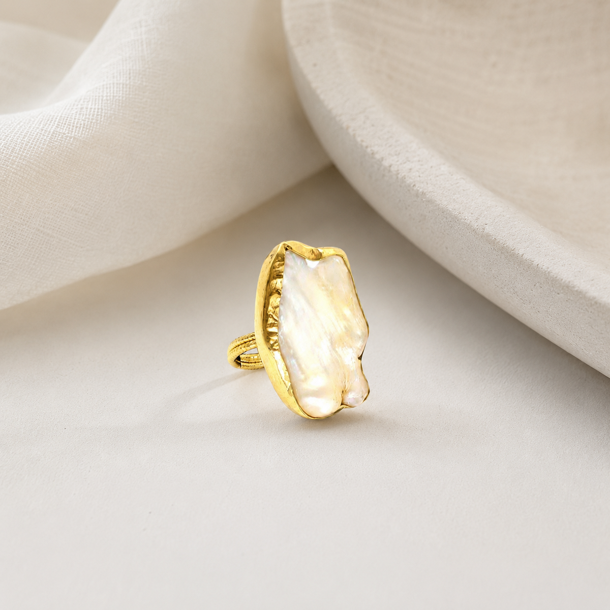 Gold-plated statement ring with an organic mother of pearl shape.
