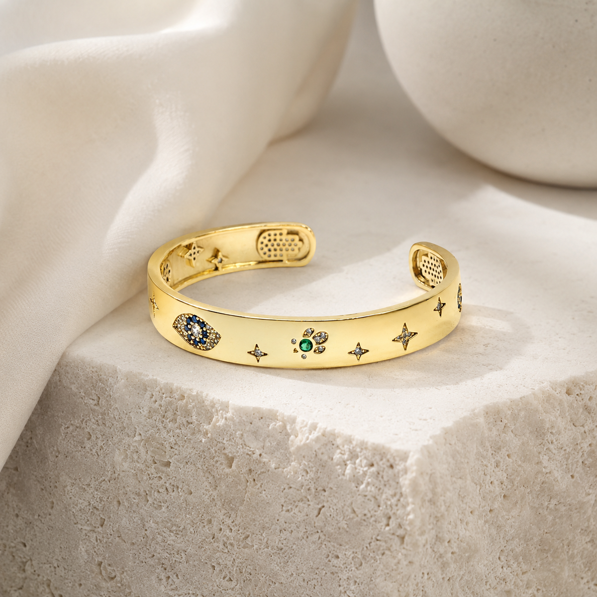 Gold-tone open cuff bracelet with a slim, curved silhouette.