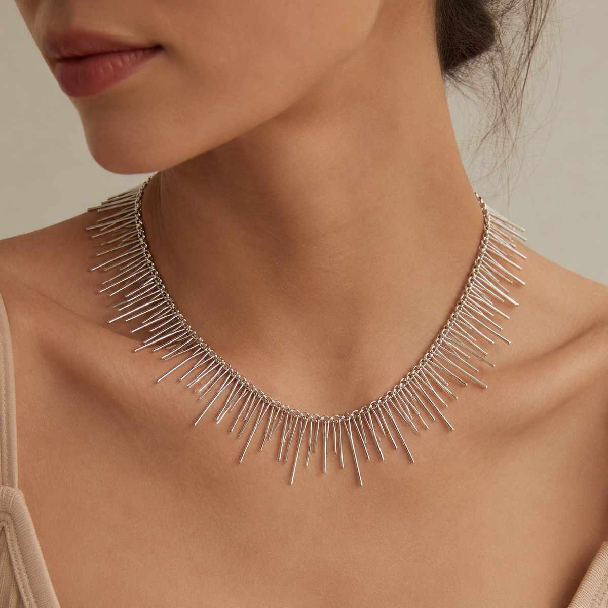 Silver-tone spike collar necklace shown from above on a white background.