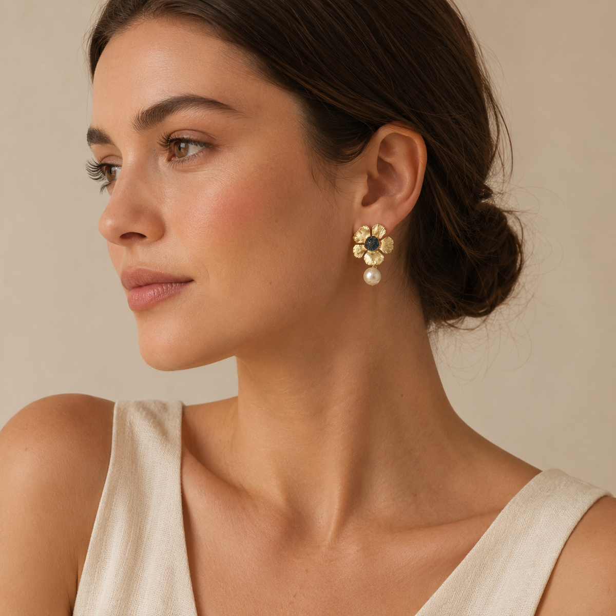 Gold flower drop earrings with a blue center and pearl drop.