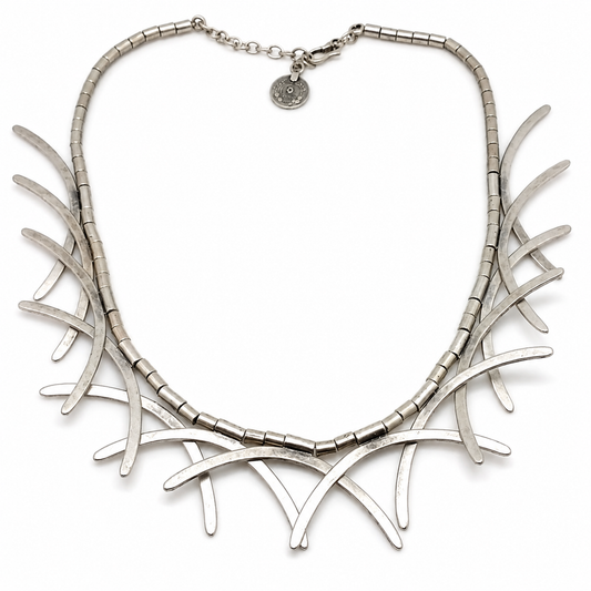 Silver-tone abstract branch collar necklace with a sculptural curved silhouette.