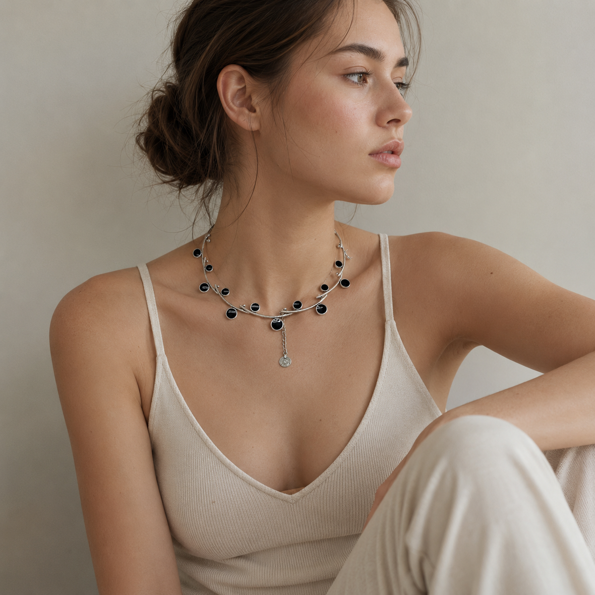 Silver-tone open wire collar necklace with black stone accents and a sculptural shape.