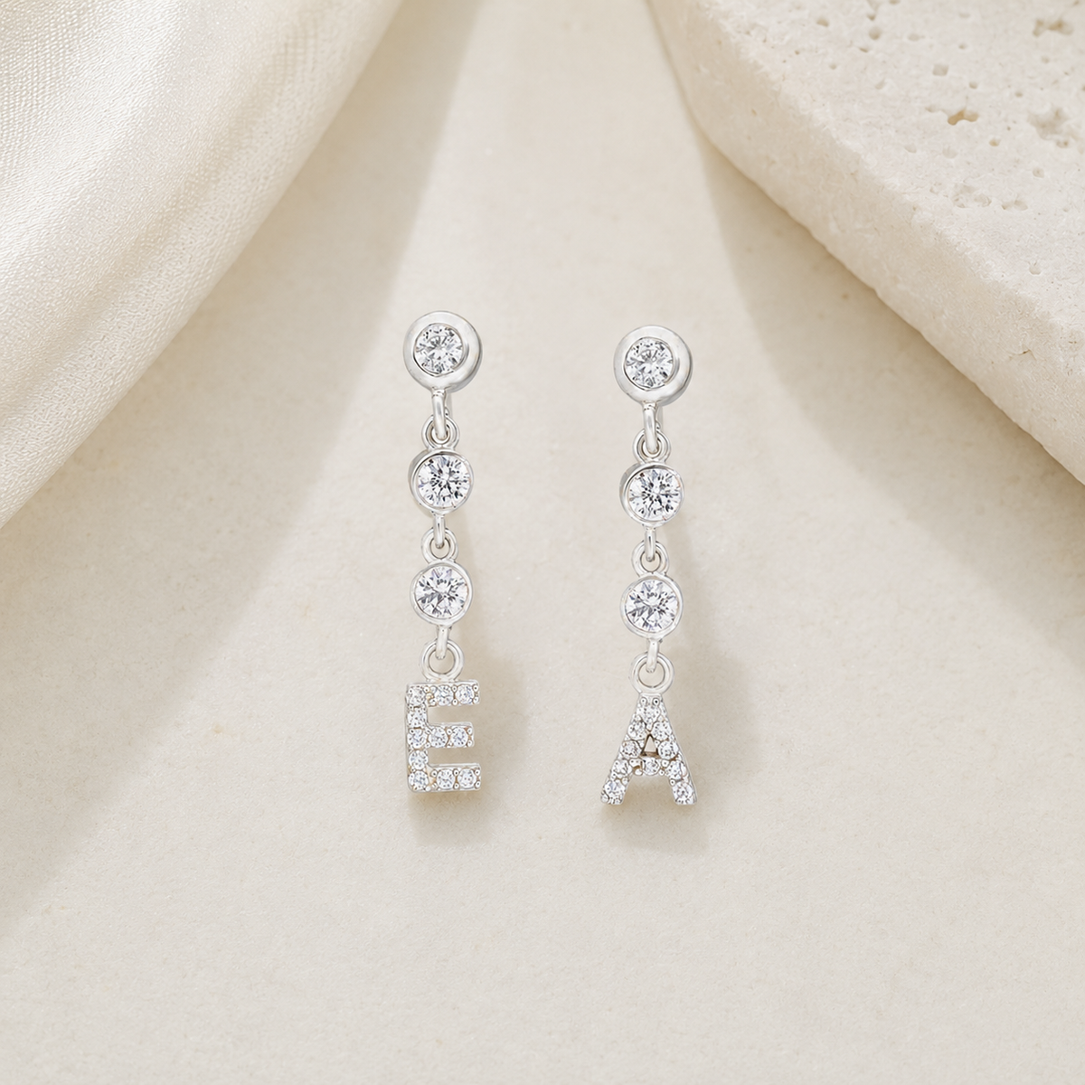 Angle view of personalized CZ chain initial dangle earrings in gold-tone finish.