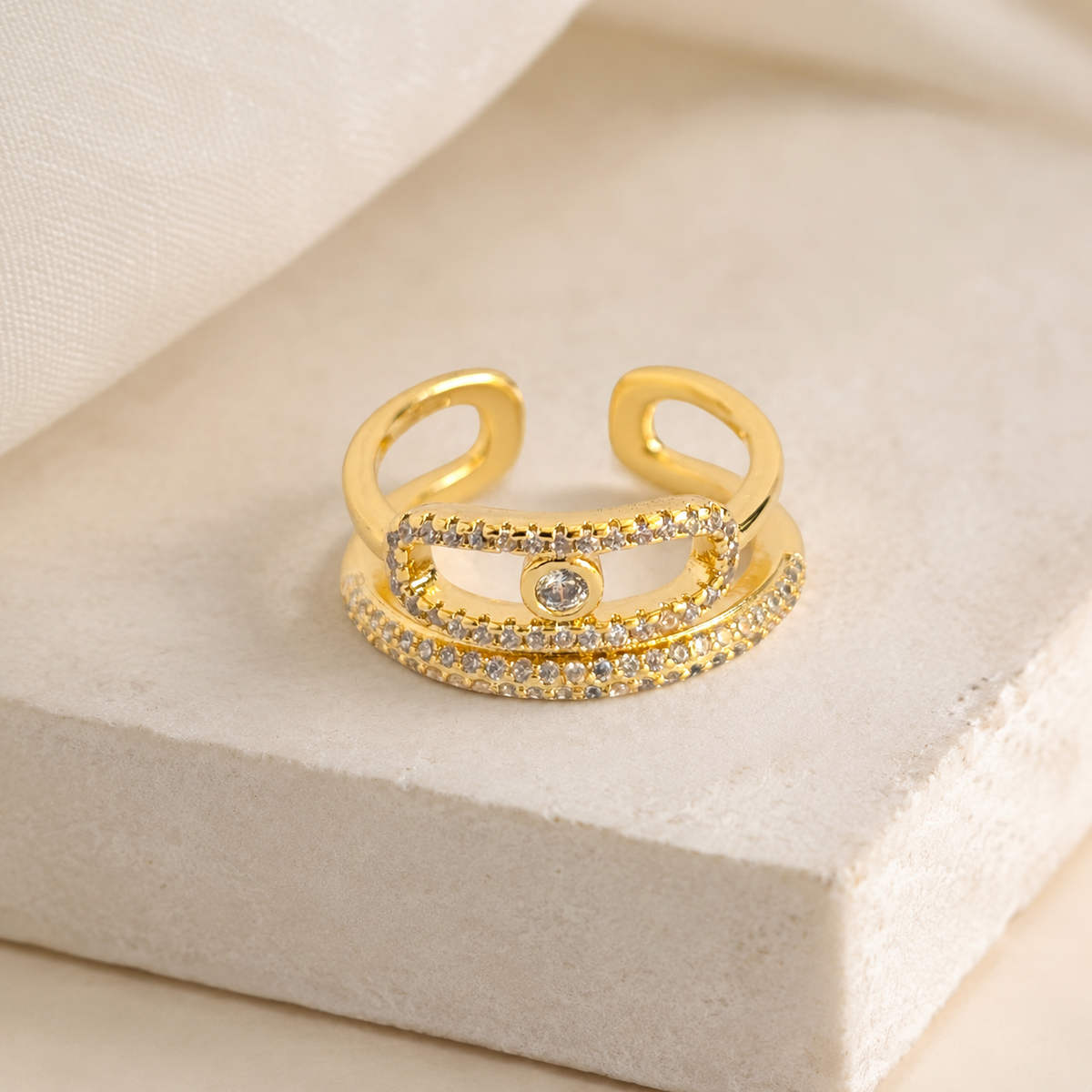 Gold-tone triple band ring with a modern wrap silhouette and clear CZ sparkle.