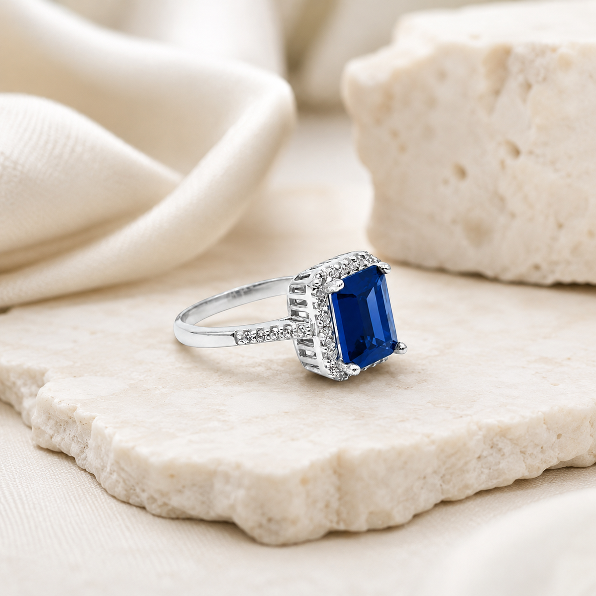 Blue sapphire ring with a polished silver-tone look and slim band.