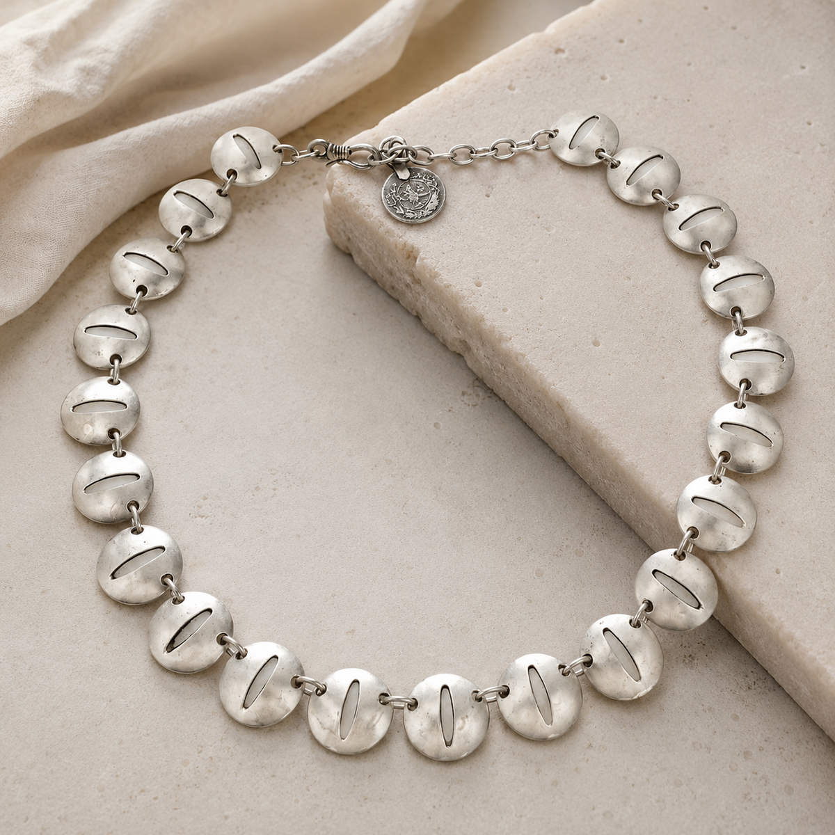 Silver-tone link necklace with a modern oval disc shape.