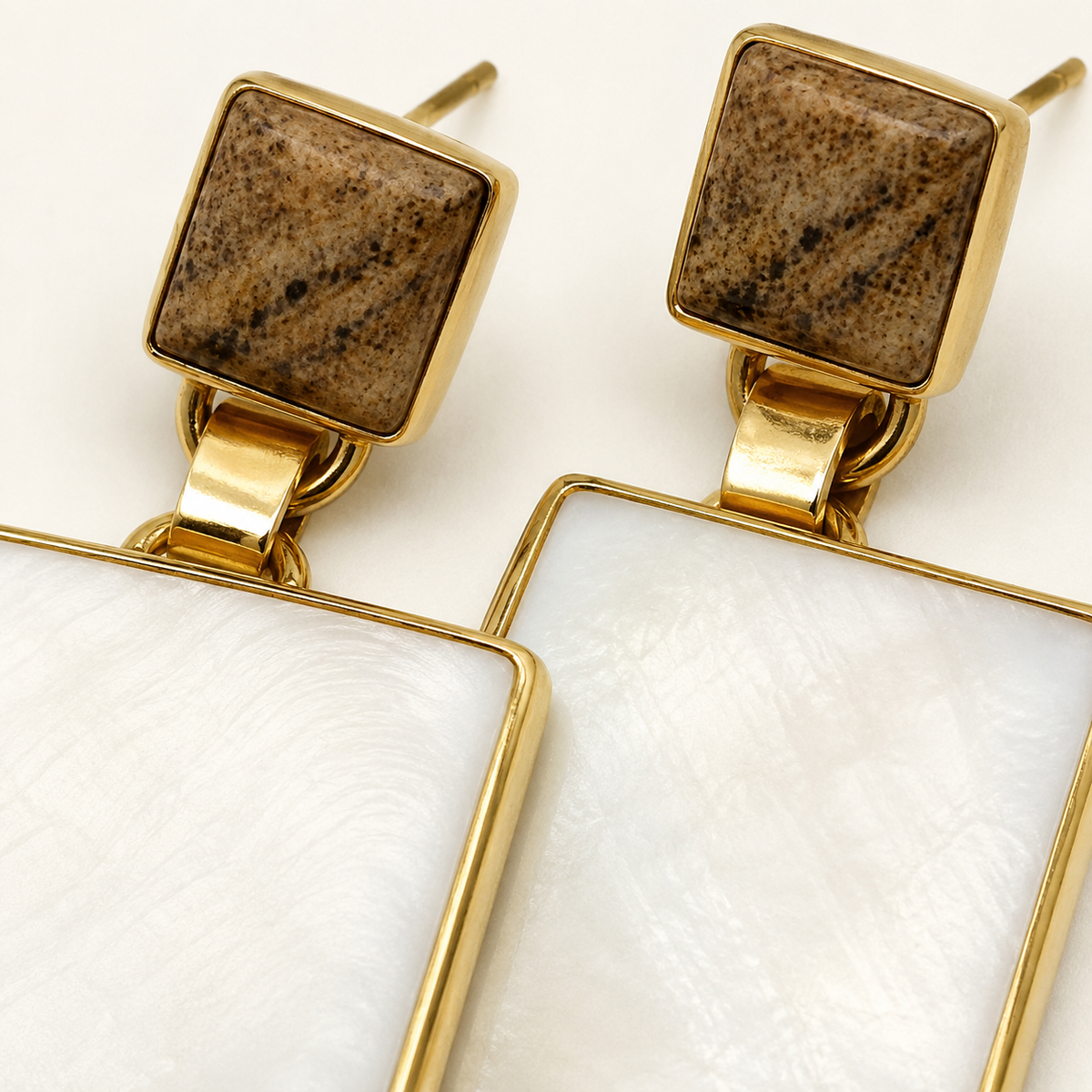 Close view of black onyx heart stud earrings with a polished gold-tone setting.