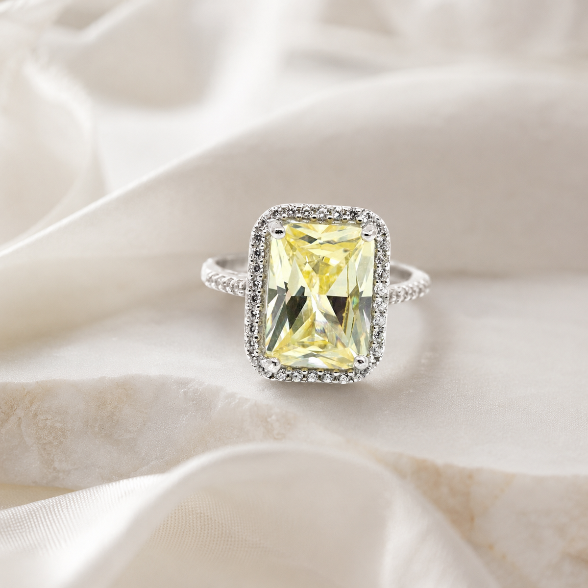 A polished canary yellow ring with a bright rectangular stone and slim band.