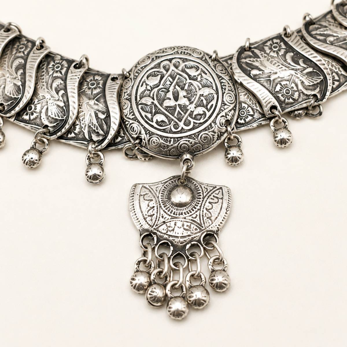 Close view of the ornate silver-tone medallion and filigree details on the choker necklace.