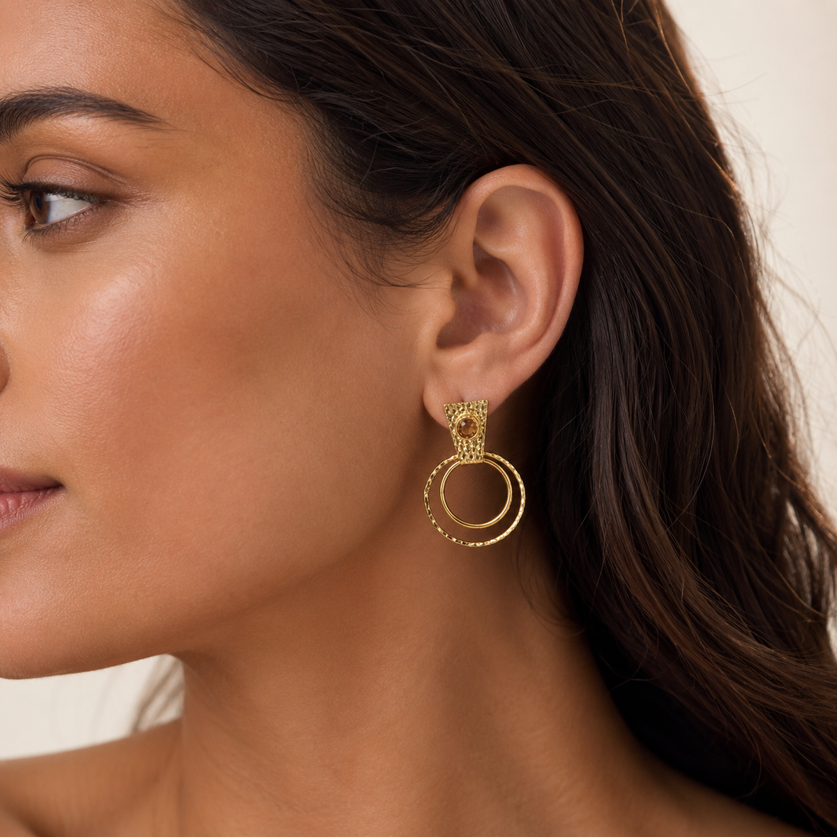Gold-plated earrings with a brown center and layered circle design.