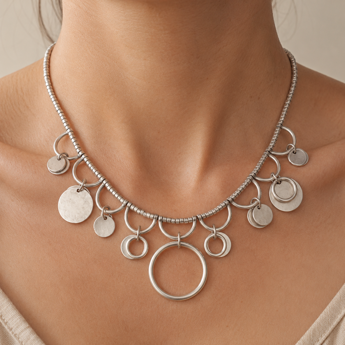 Silver-tone collar necklace with layered ring charms.