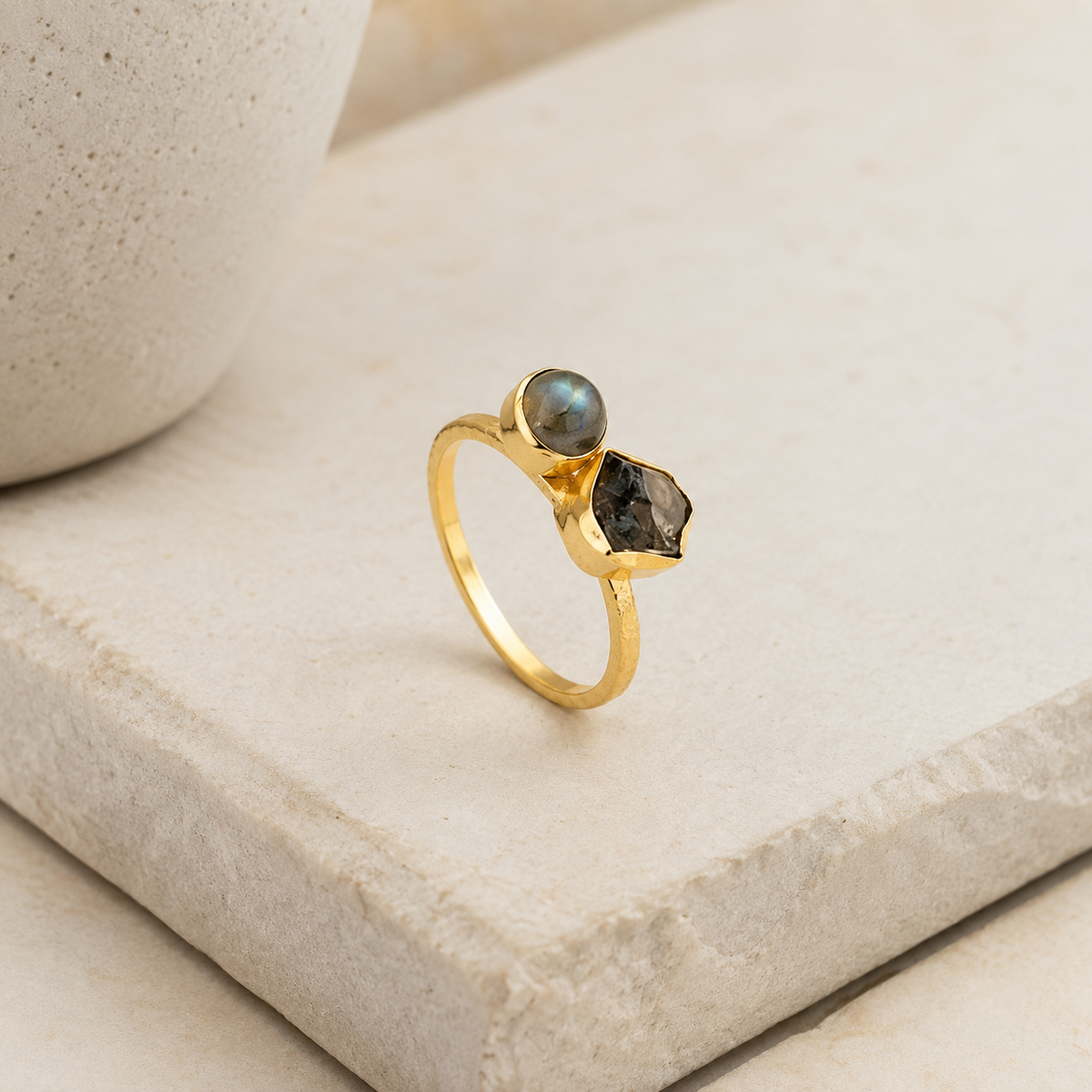 Angled view of a gold-plated ring with labradorite and smoky quartz stones.