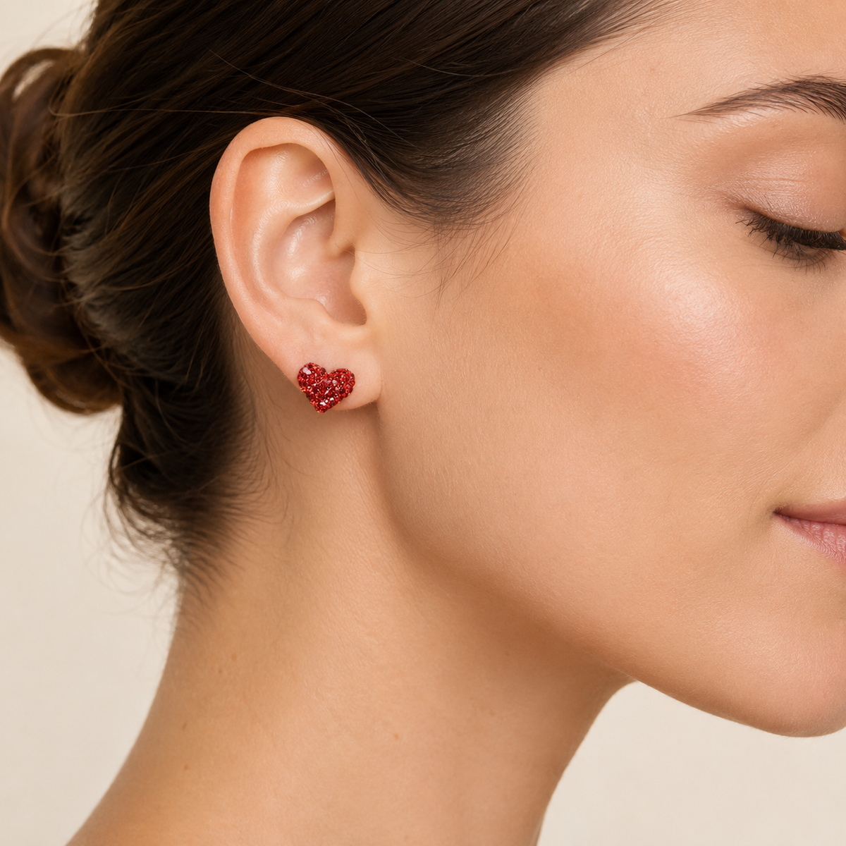 Pair of red crystal heart stud earrings shown front view on a white background.
