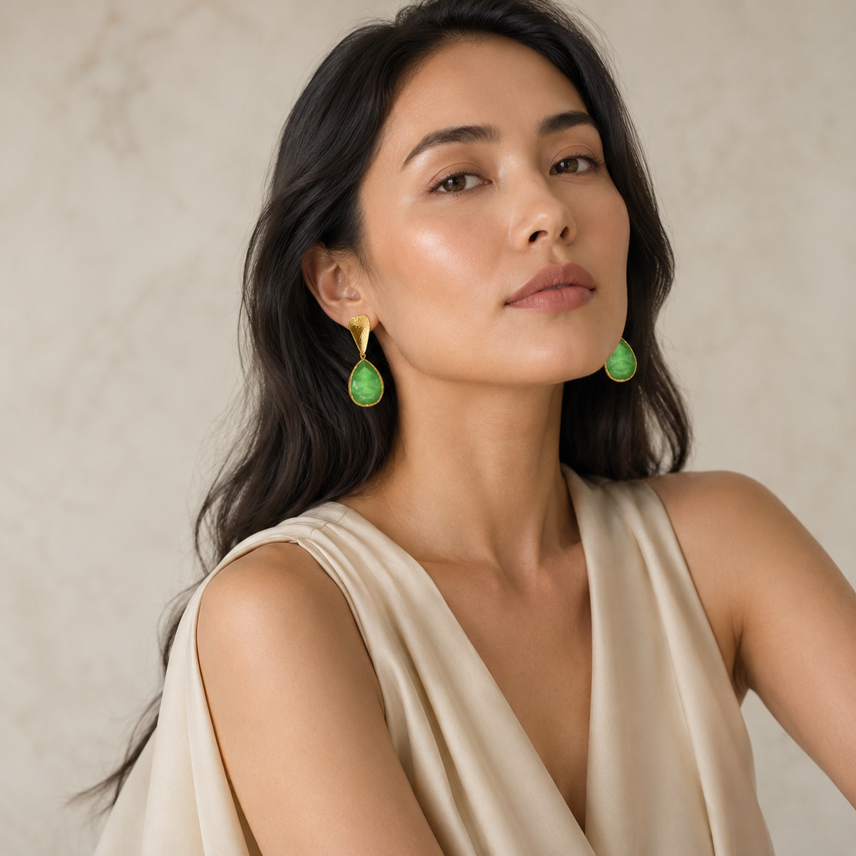 Green teardrop earrings with a textured gold finish.