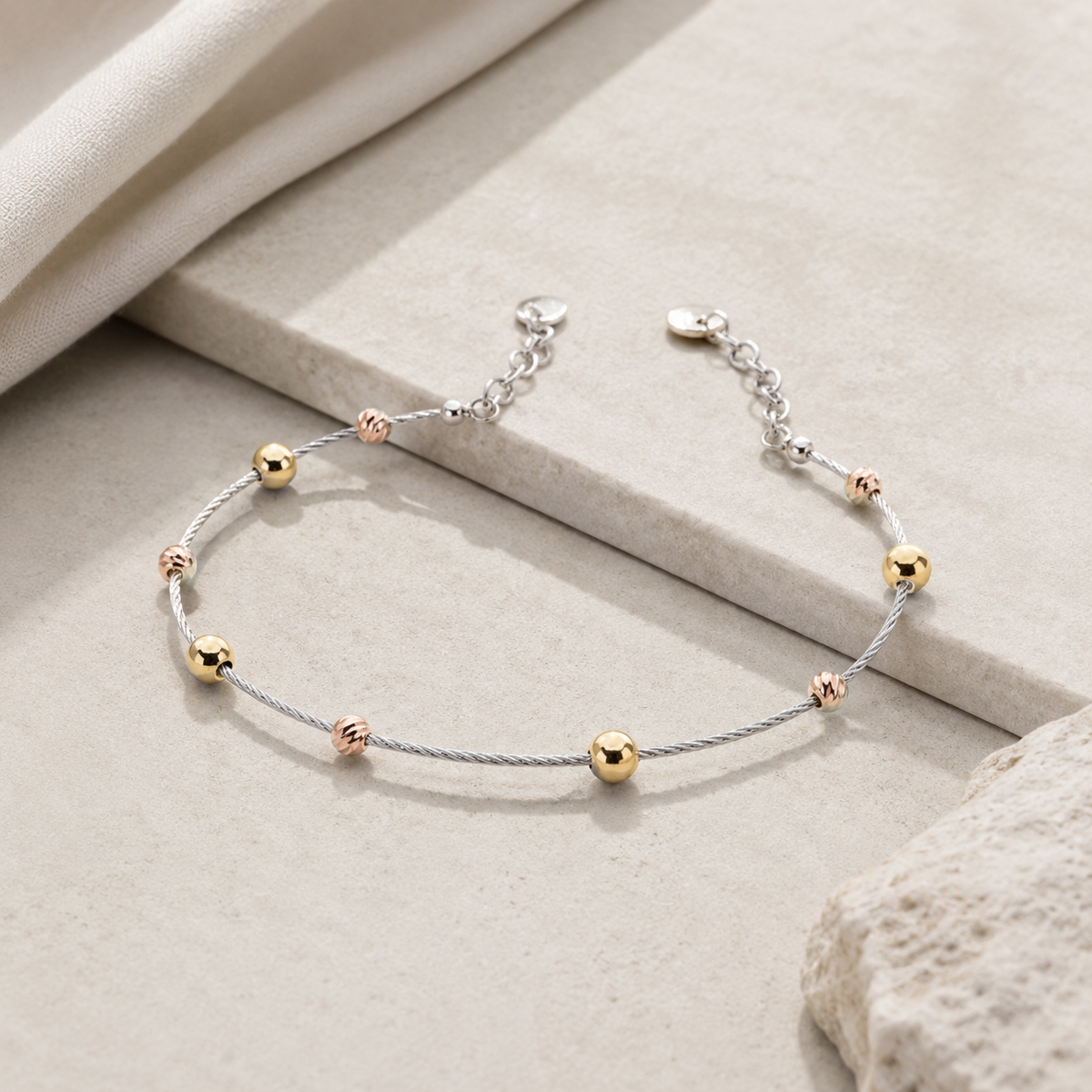 Silver bracelet with spaced gold bead accents shown from above.
