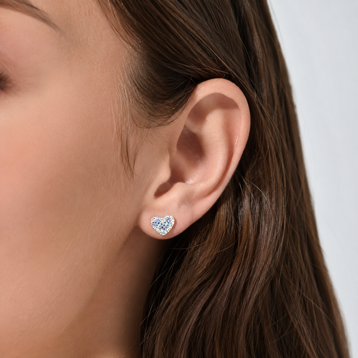 Heart-shaped stud earrings shown side by side with a bright, multicolor sparkle finish.