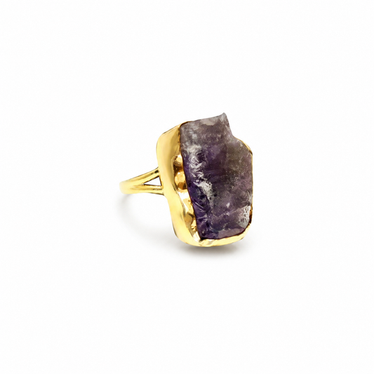 Raw amethyst statement ring with a gold-plated setting on a white background.