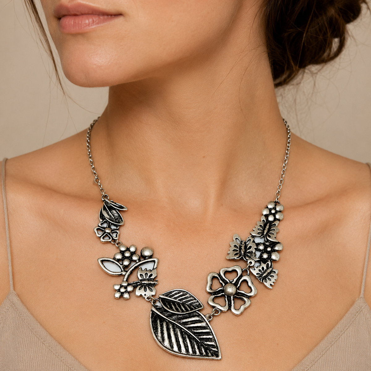 Silver-tone floral leaf statement necklace shown from the front.