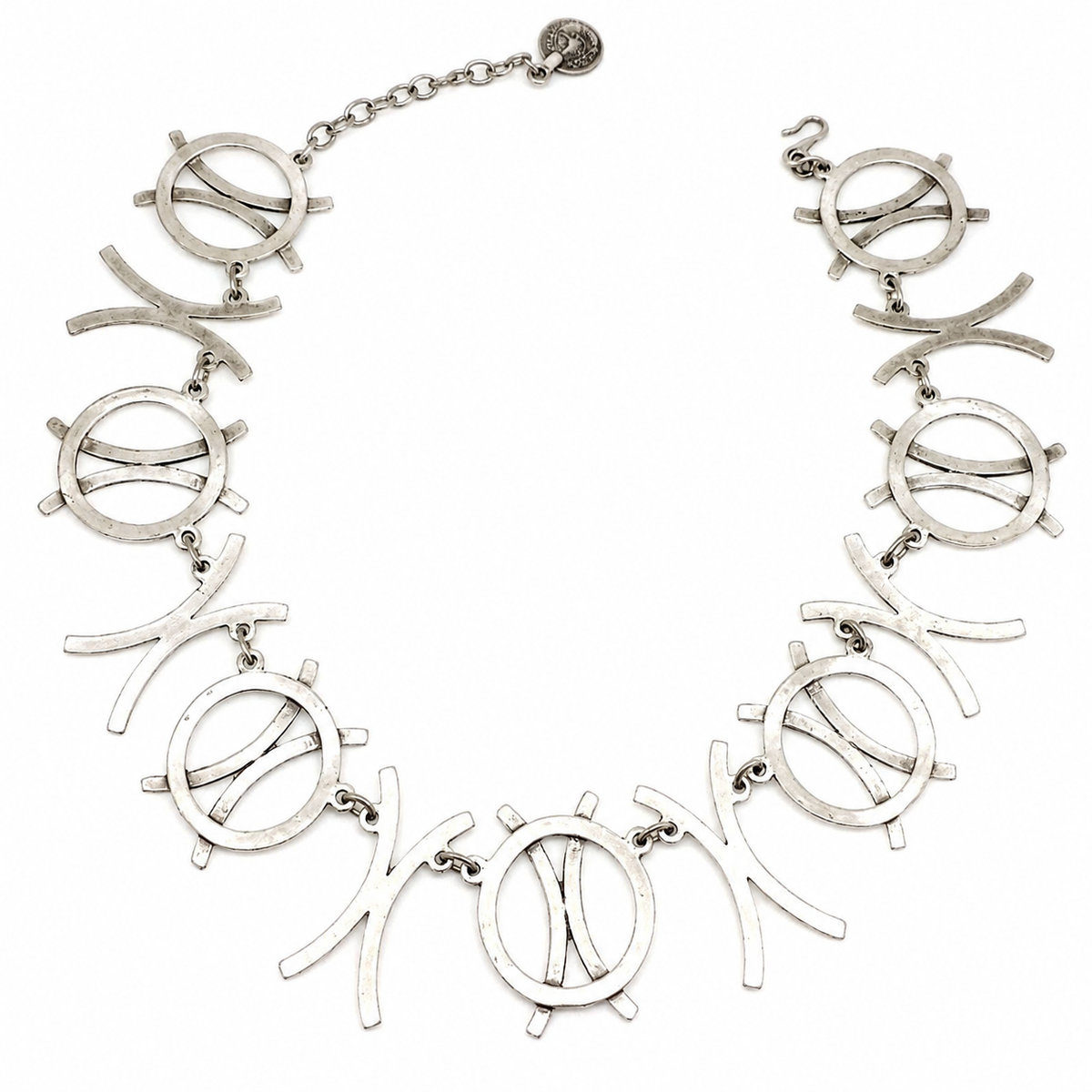 Silver-tone necklace with linked circle symbols and curved shapes on a white background.