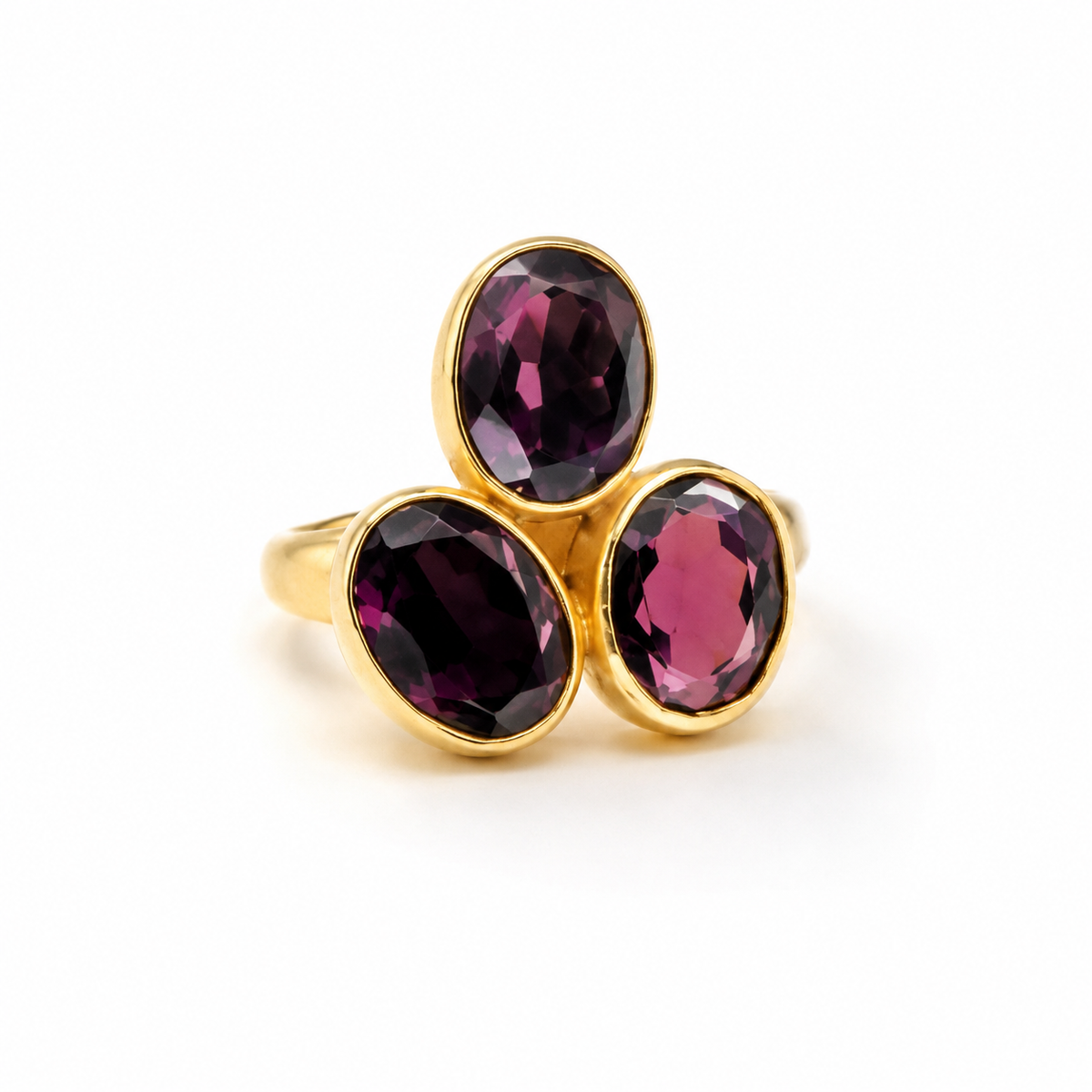Gold-plated ring with three oval amethyst stones in deep purple tones.