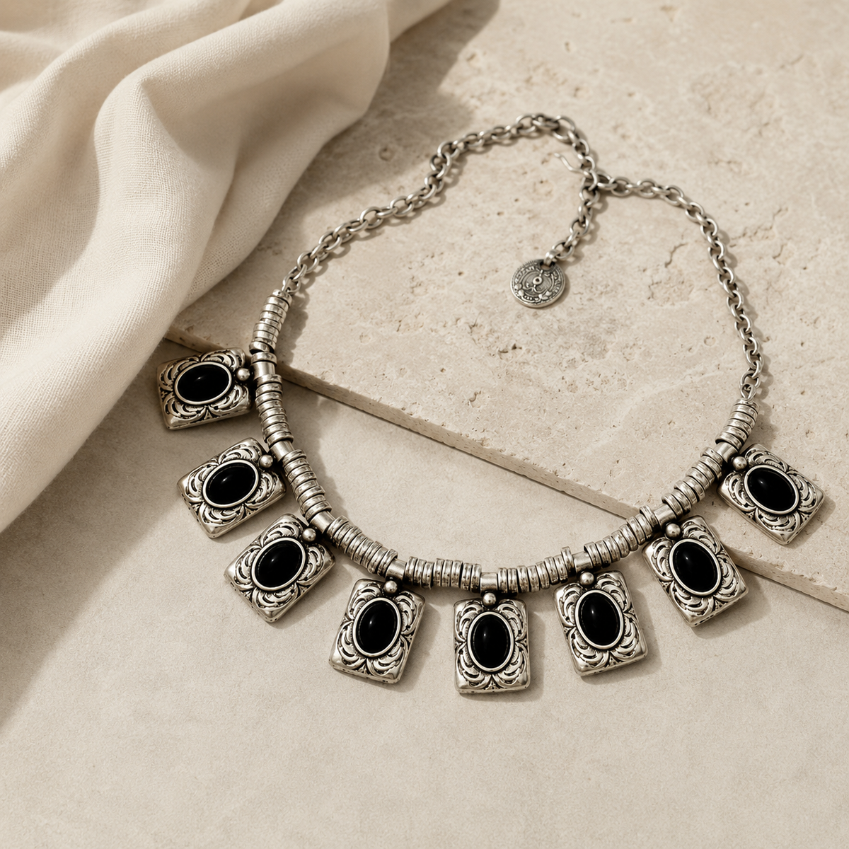 Silver-tone necklace with multiple black rectangular charms arranged in a bold silhouette.