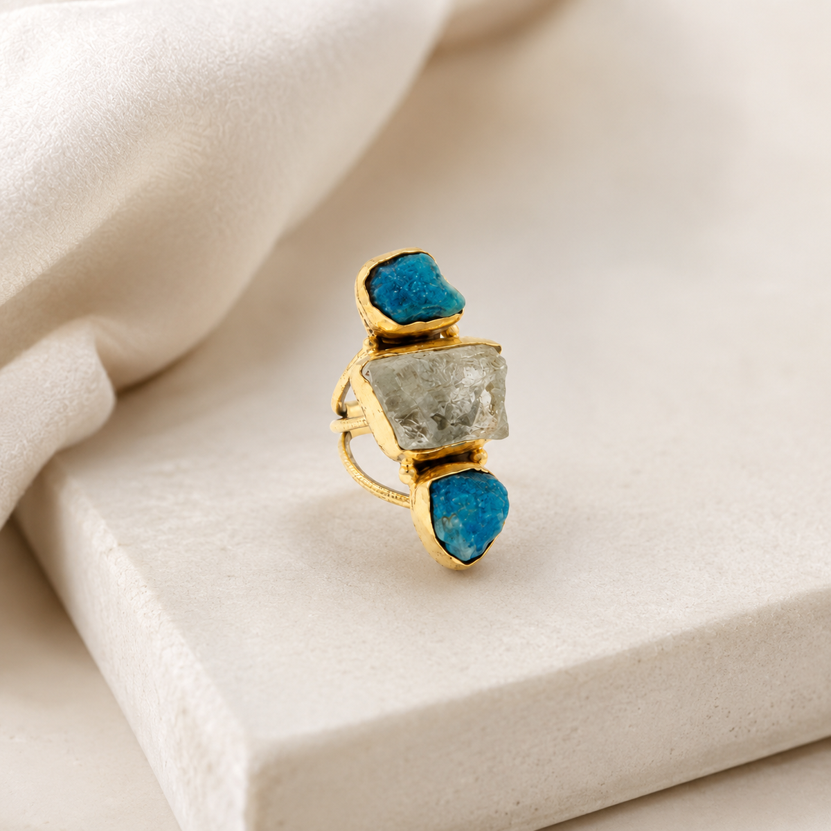 Gold-plated statement ring with a sculptural three-stone design.