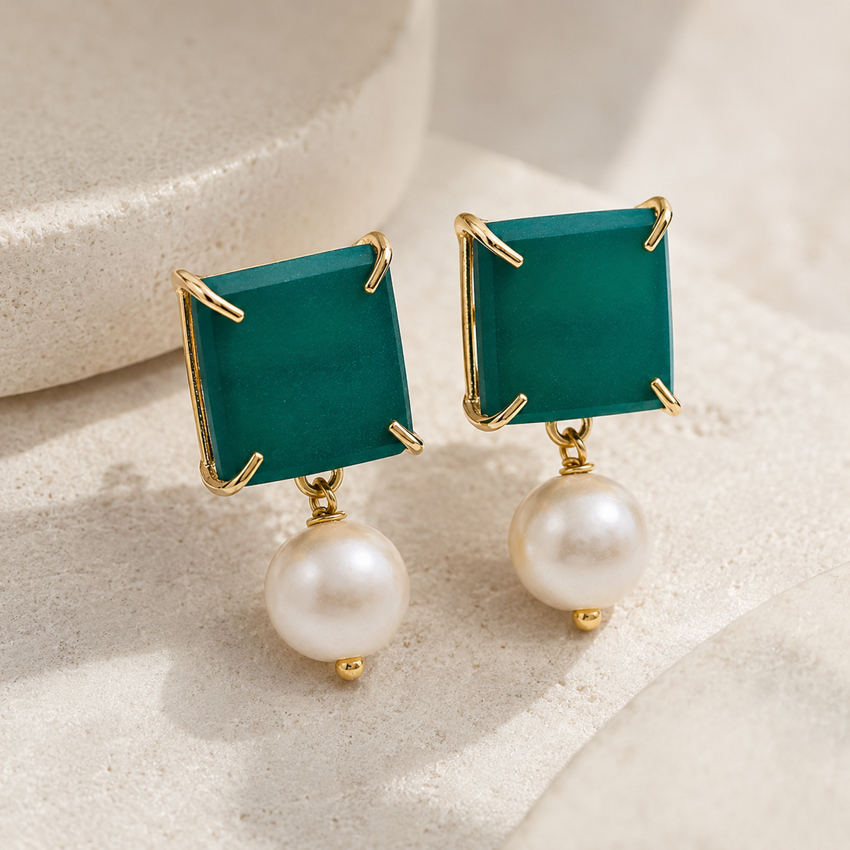 Angled view of green chalcedony and pearl drop earrings with gold-plated details.