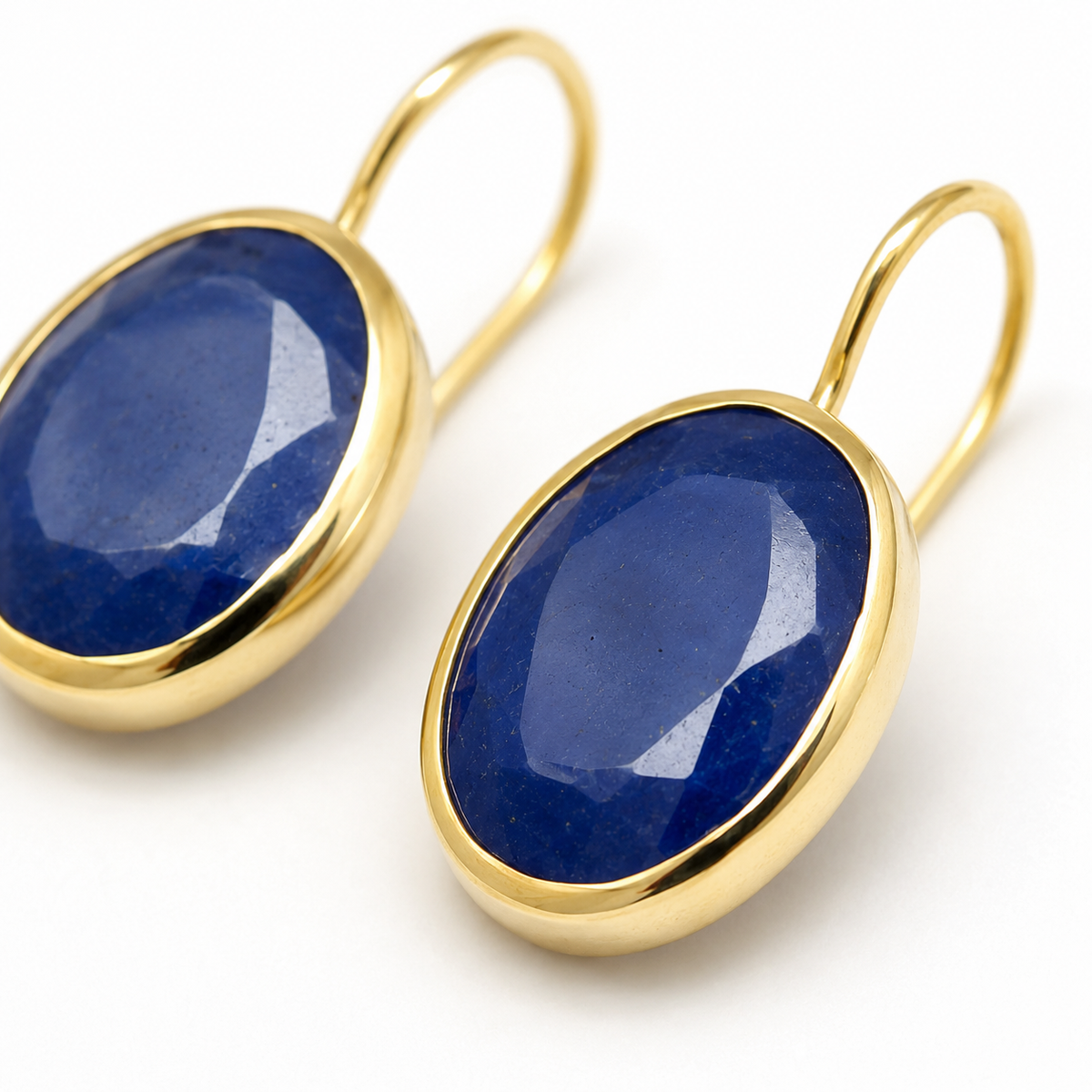 Close view of the faceted blue stone and gold-plated setting.