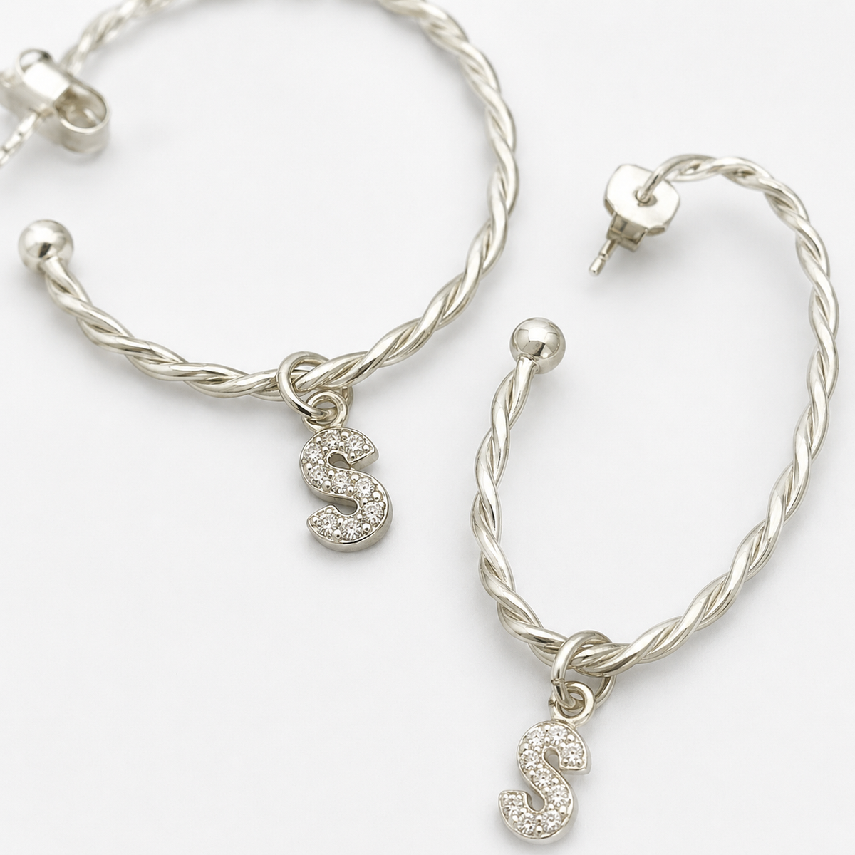 Close view of the twisted hoop texture and CZ initial charm.