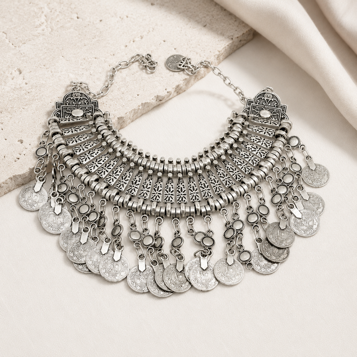 Silver-tone boho necklace with a wide bib shape and dangling coin charms.