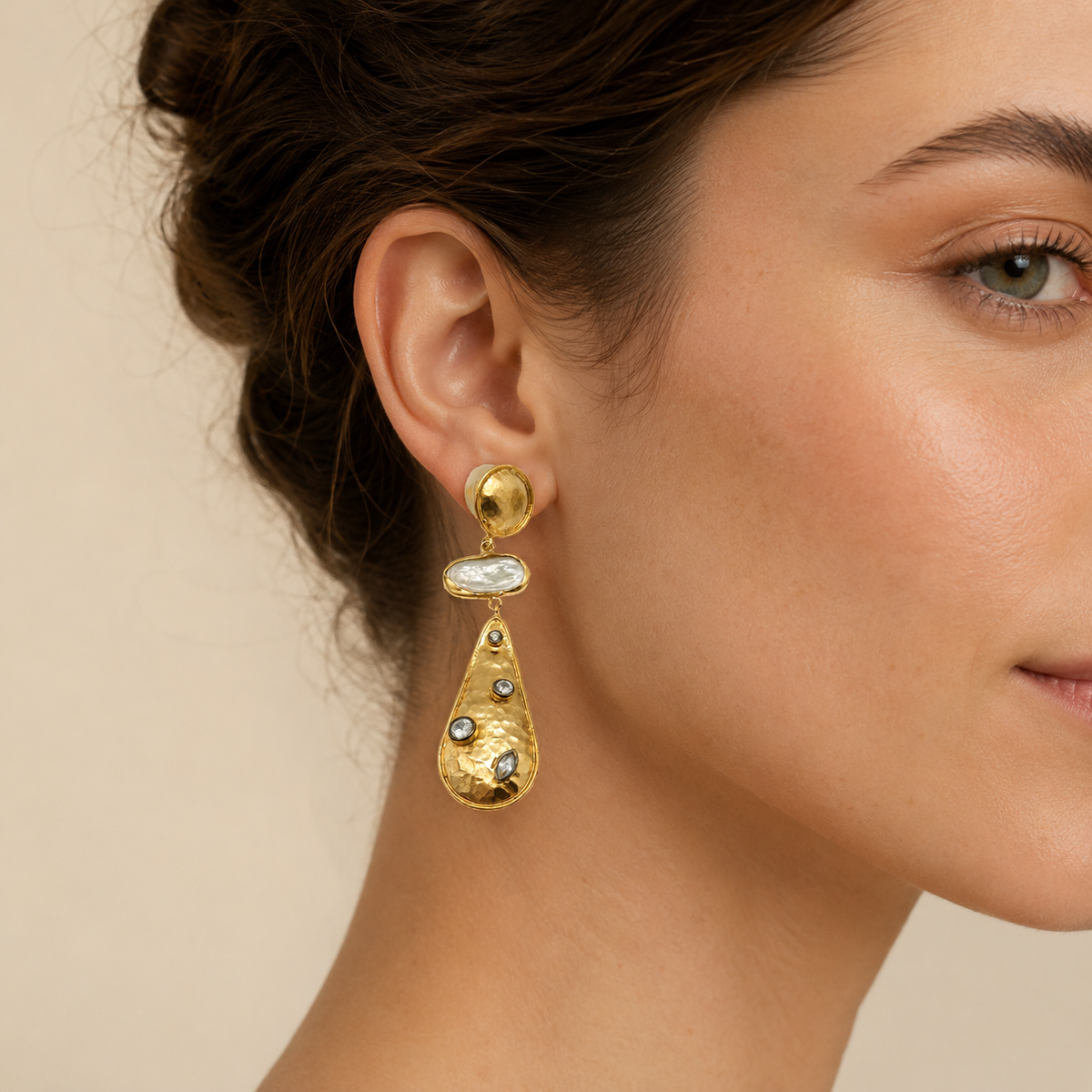 Pair of gold statement earrings with a sculptural drop shape.