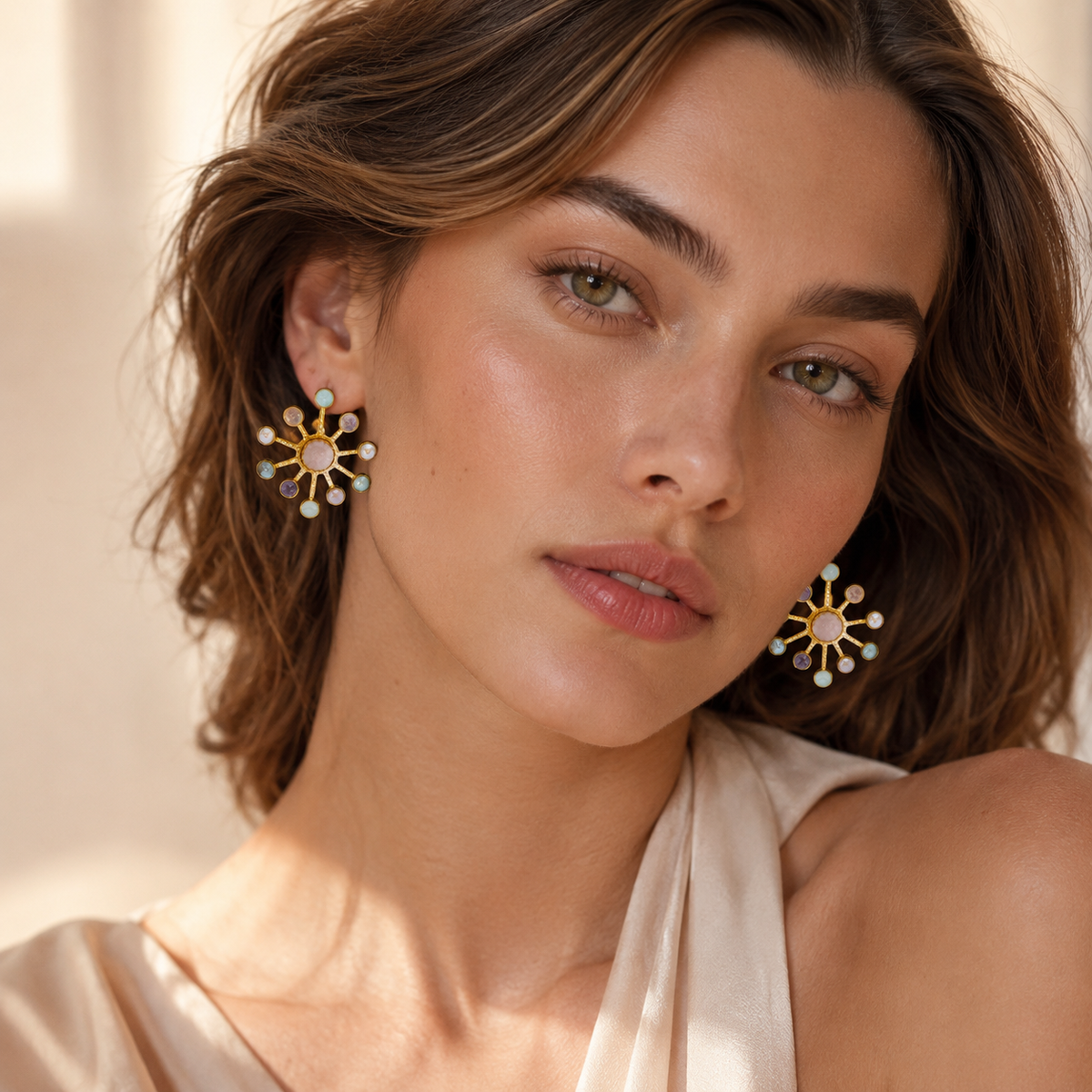 Pair of starburst statement earrings with multicolor gemstone-style accents and a gold-plated look.