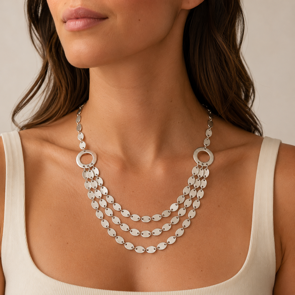 Layered silver-tone oval link necklace shown on a white background.