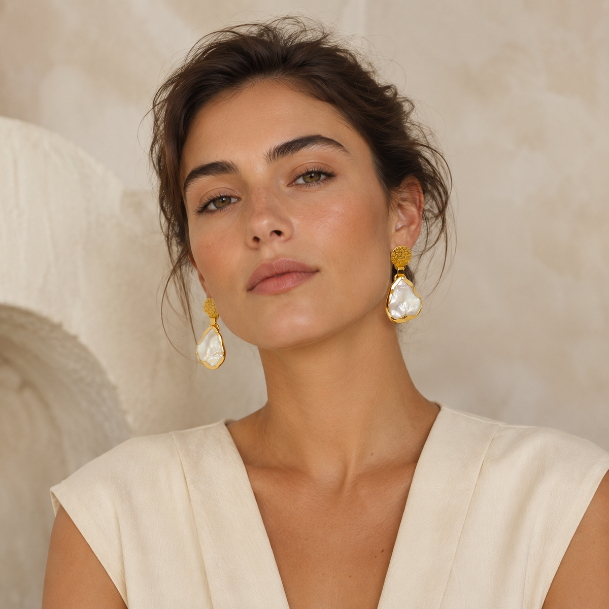 Mother of pearl drop earrings with a polished gold-plated frame and textured stud tops.