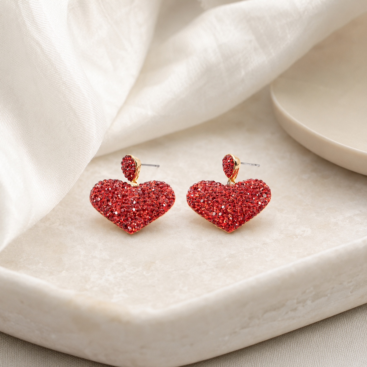 Red crystal heart stud earrings with a gold-plated finish styled on a white background.
