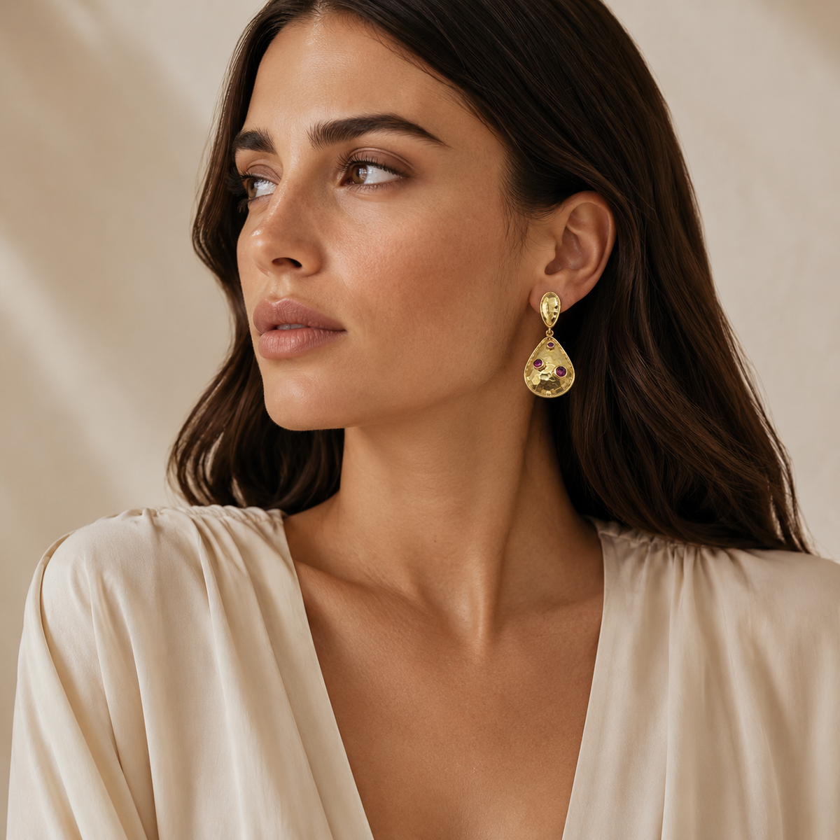 Gold-plated teardrop earrings with clear crystal accents shown as a pair.