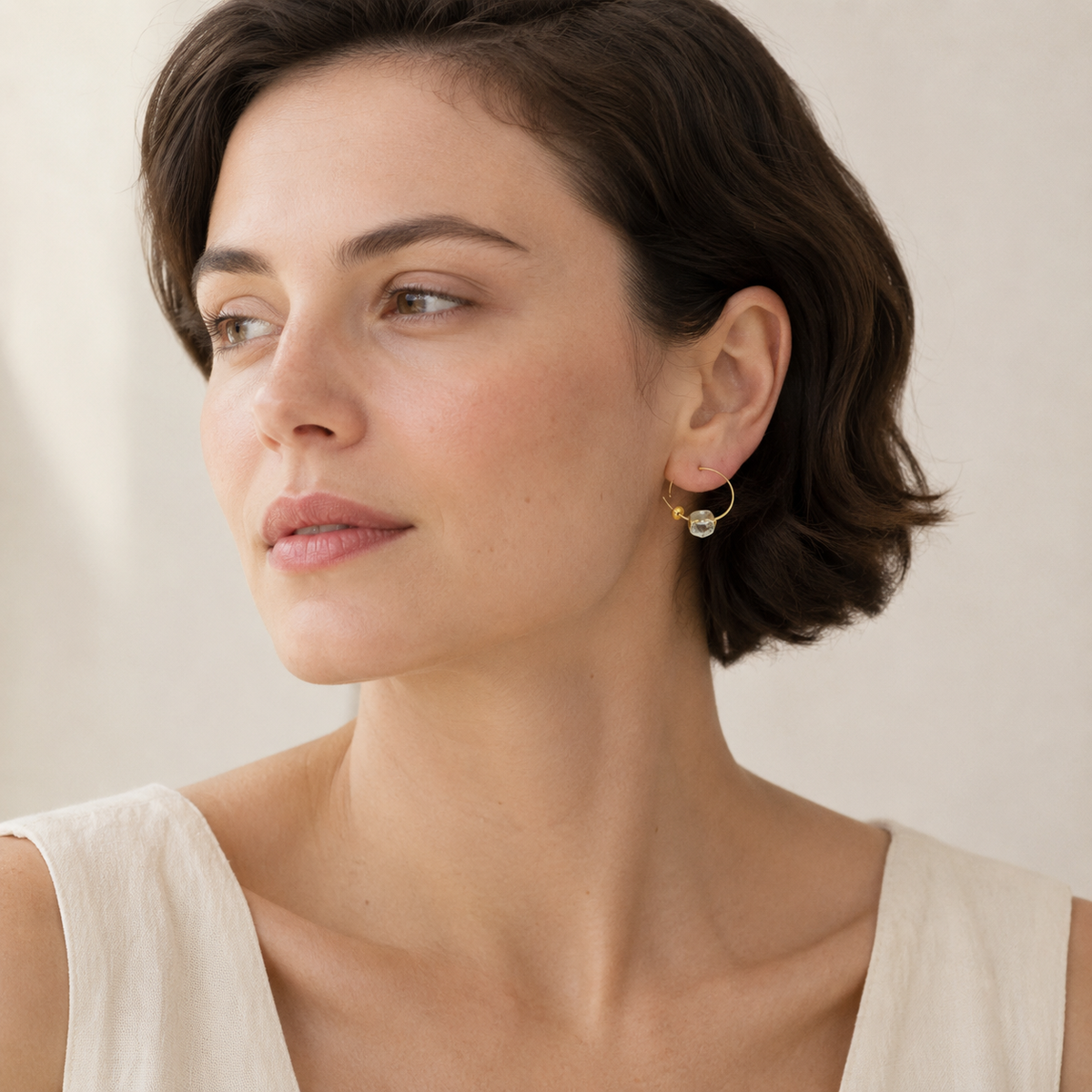 Pair of yellow solar quartz hook earrings in a simple studio view.