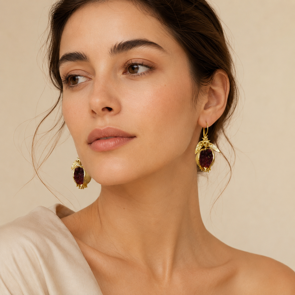 Pair of gold-plated earrings with rich red stone details.