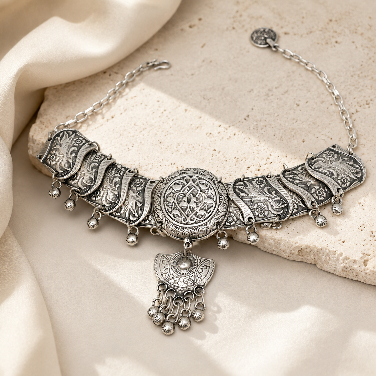 Silver-tone filigree choker necklace with a detailed centerpiece and dangling accents.