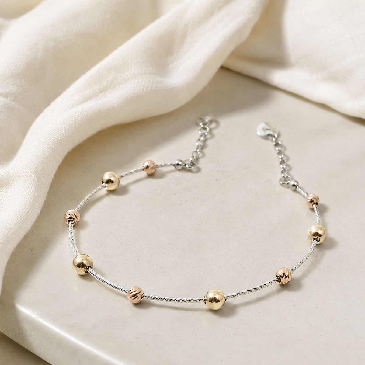 Minimal mixed-metal bracelet with a delicate cable silhouette.