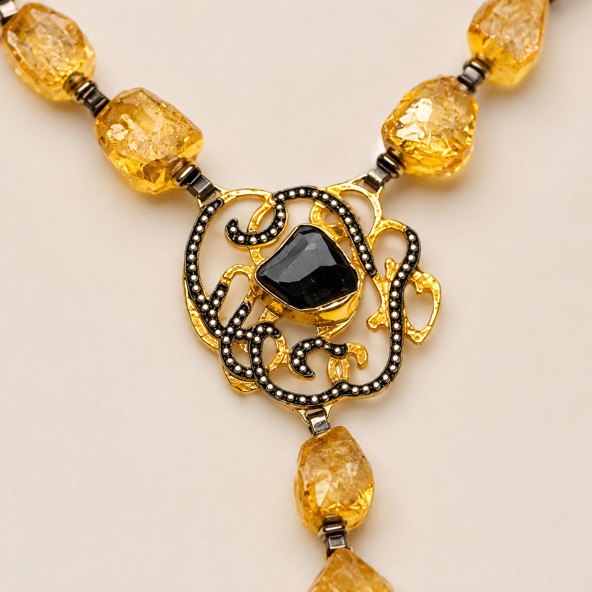 Close view of the ornate medallion pendant and citrine-toned stones.