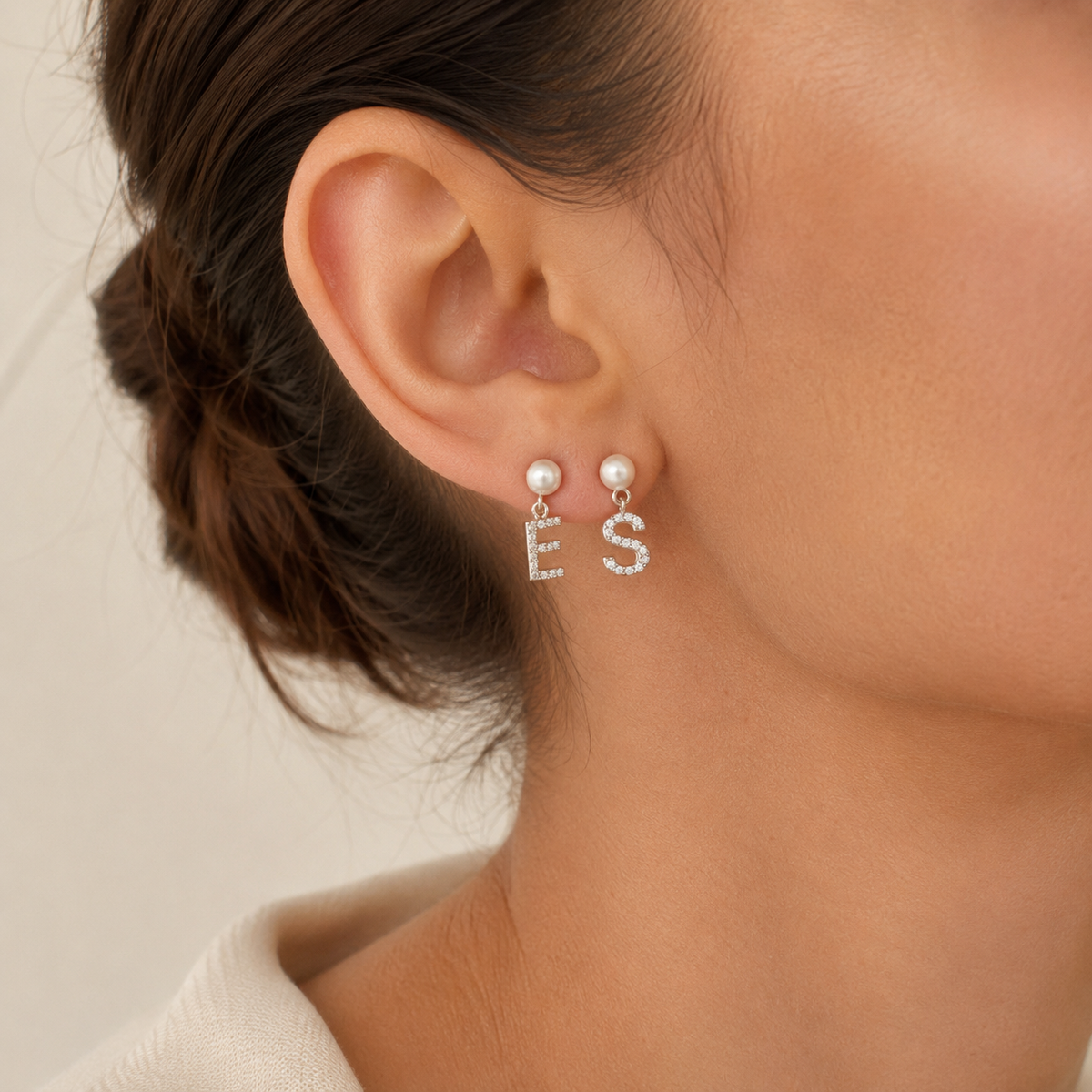 Pair of personalized pearl and CZ initial dangle earrings on a white background.
