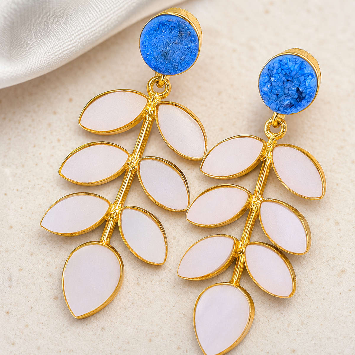 Close view of the blue druzy and polished gold-plated setting on the earrings.