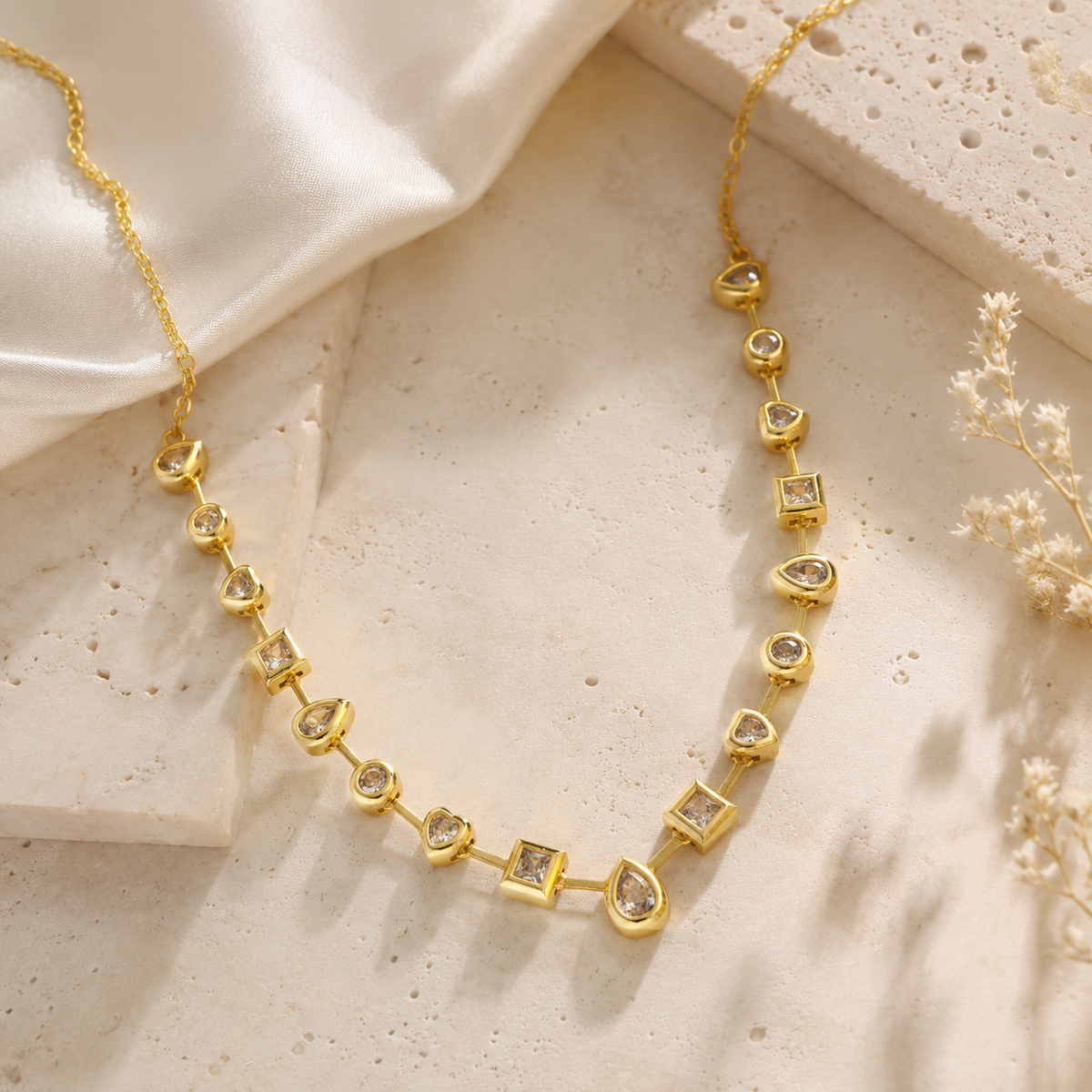 Gold-tone necklace with mixed shape clear stones in a delicate station design.